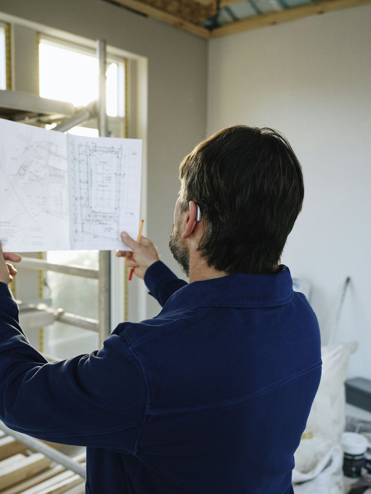 Estimator reviewing construction plans on a job site